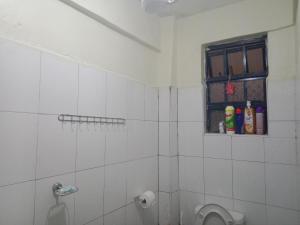 a bathroom with a shower with a toilet and a window at SHAHMERALD Stays Studio in Kakamega