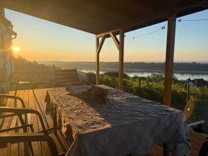 a table on a deck with the sunset in the background at Danube House in Mohács
