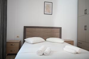 a bedroom with a bed with two towels on it at Mandi's Apartment in Ksamil