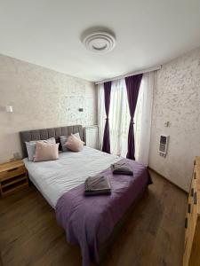 a bedroom with a large bed with purple sheets at Dream Apart - Iceberg in Pamporovo