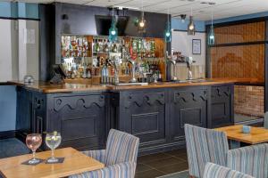 a bar in a restaurant with two tables and chairs at Hotel St Pierre, Sure Hotel Collection by Best Western, Newmillerdam, Wakefield in Wakefield