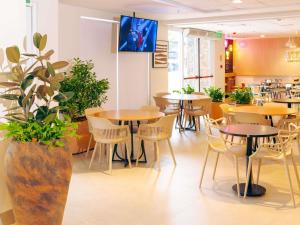 a dining room with tables and chairs at ibis Styles Goiania Marista in Goiânia
