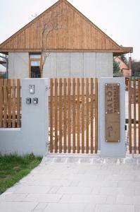 a fence with a gate with a sign in front of it at Kalóz apartmanház Velence in Velence