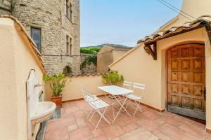 a patio with a table and chairs in front of a building at Amour de Provence in Nyons