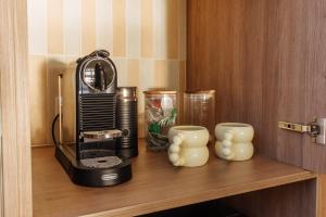 a black blender on a wooden shelf with two cups at Casa Airlie in Airlie Beach +27 photos