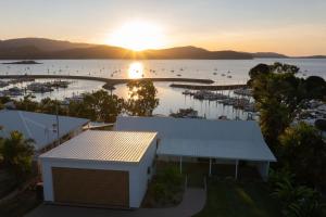 a sunset over a marina with boats in the water at Casa Airlie in Airlie Beach