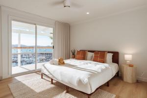 a bedroom with a large bed and a large window at Casa Airlie in Airlie Beach