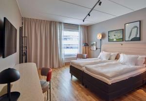 a bedroom with a large bed and a table at Scandic Kiruna in Kiruna +50 photos