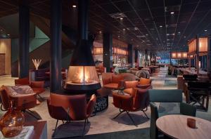 a restaurant with a fireplace and chairs and tables at Scandic Kiruna in Kiruna