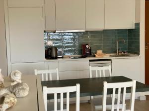 a kitchen with a table and chairs and a sink at Il Piccolo Cristallo sul Mare in Santa Marinella