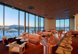 a lobby with couches and tables and large windows at Scandic Kiruna in Kiruna