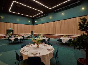 a banquet hall with tables and chairs and tablesktop at Scandic Kiruna in Kiruna