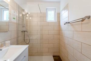 a white bathroom with a shower and a sink at Gîte La Motette Drôme Provençale in Rousset-les-Vignes