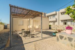 a patio with a table and chairs and a building at Aspasia House in Platanias