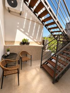 a balcony with a staircase and a table and chairs at Giorgos House Attic in Gialova