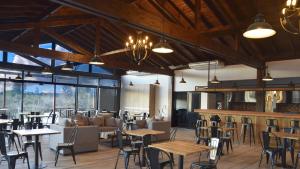 a restaurant with tables and chairs and windows at Cabañas Boutique Pipi Cucu in Colón