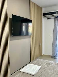 a bedroom with a bed with a flat screen tv on the wall at Salt & Sea in Sarti