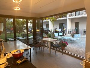 a room with tables and chairs and a patio at Vila Lazri in Shëngjin