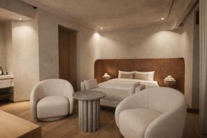 a bedroom with a bed and two chairs and a table at Porto Antico in Chania