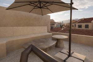 a patio with a table and an umbrella at Porto Antico in Chania +25 photos