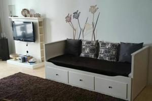 ein Sofa mit Kissen und einen TV im Wohnzimmer in der Unterkunft Patio 1 in Bremen