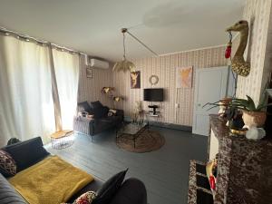 a living room with a couch and a table at Chambre bleue in Vigneulles-lès-Hattonchâtel