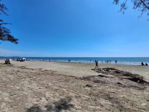 a group of people on a sandy beach at CBR Beach in Kota Belud