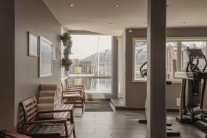 a living room with chairs and a gym with a view at Home Hotel Aurora in Tromsø