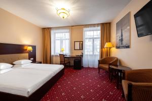 a hotel room with a bed and a desk at Rixwell Old Riga Palace Hotel in Riga