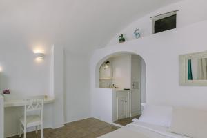 a white room with a bed and a desk at Afroessa Hotel by Caldera Houses in Imerovigli