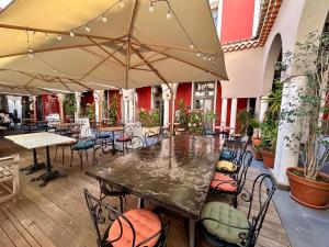 a patio with a table and chairs and umbrellas at Hôtel De Paris in Sète