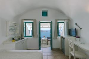 a kitchen with a sink and a kitchen with a view of the ocean at Afroessa Hotel by Caldera Houses in Imerovigli +205 photos