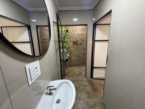 a bathroom with a sink and a shower at 16 st Johns - Studio 2 in Port Shepstone +4 photos