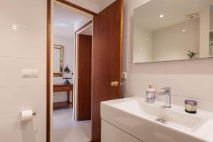 a white bathroom with a sink and a mirror at Lets Holidays INCREDIBLE APARTMENT WITH AMAZING VIEWS in Tossa de Mar +26 photos