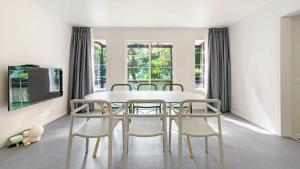 a white dining room with a white table and chairs at Gapyeong Dangdangi Pet Pension Green in Gapyeong