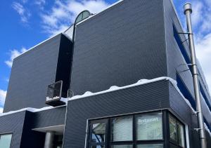 a black building with a sign on the side of it at Zao Sunvalley Hotel in Yamagata