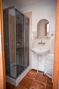 een badkamer met een glazen douche en een wastafel bij Pokoje u Anastazji in Zakrzewo