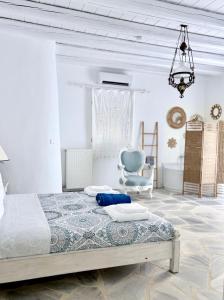 a bedroom with a bed and a blue chair at Koundouros 186 View in Koundouros +38 photos