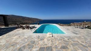 a swimming pool on a patio with a view of the ocean at Koundouros 186 View in Koundouros