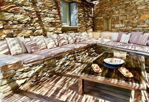 a stone wall with a couch and a table at Koundouros 186 View in Koundouros