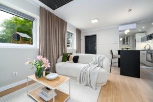 a living room with a white couch and a table at Aparthotel Cieplice in Jelenia Góra +7 photos