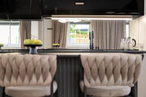 a kitchen with a counter with two bar stools at Aparthotel Cieplice in Jelenia Góra