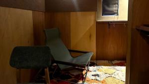 a green chair in a room with a window at MAGATAMA.INN in Sumoto