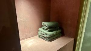a stack of towels sitting on a shelf in a bathroom at MAGATAMA.INN in Sumoto