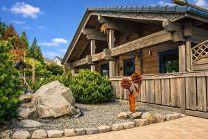 a wooden house with a fence and a rock at Chalet Hahnenklee in Goslar