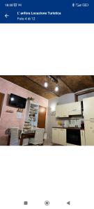 a view of a kitchen with white cabinets and chairs at L' anfora Locazione Turistica in Terni +11 photos