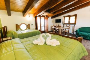 two swans sitting on a bed in a room at The Chalet, guest house in Agerola