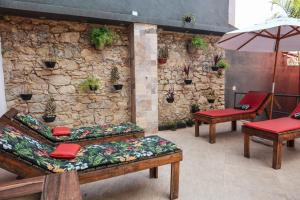 a patio with benches and chairs and a stone wall at Guesthouse Villa Dourada in Rio de Janeiro +35 photos