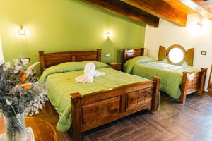 two beds in a room with green walls at The Chalet, guest house in Agerola