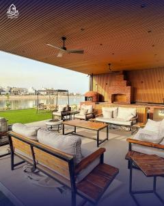 a patio with couches and tables and a view of the water at Paradise in Al Khīrān